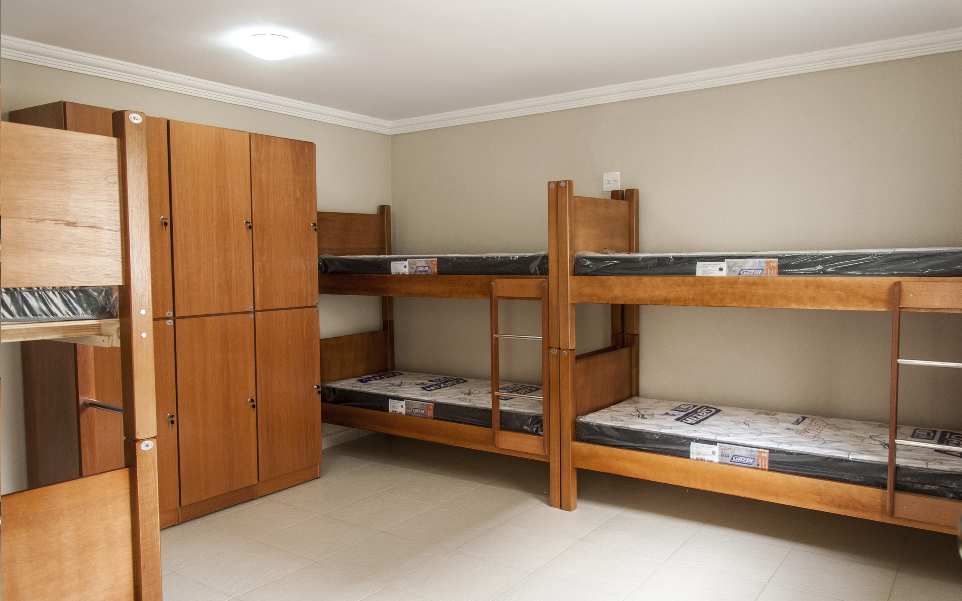 Quarto com beliches de madeira e armários individuais